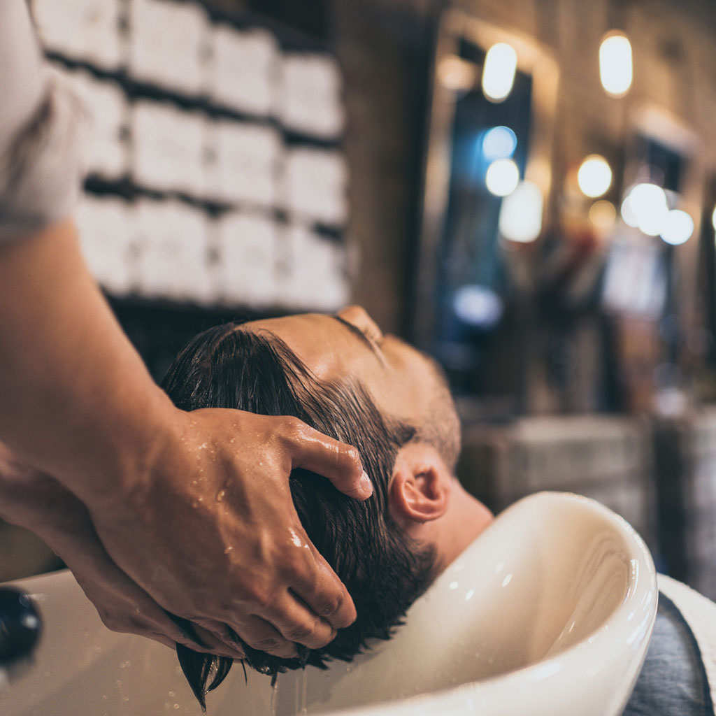 Mann bekommt die Haare gewaschen